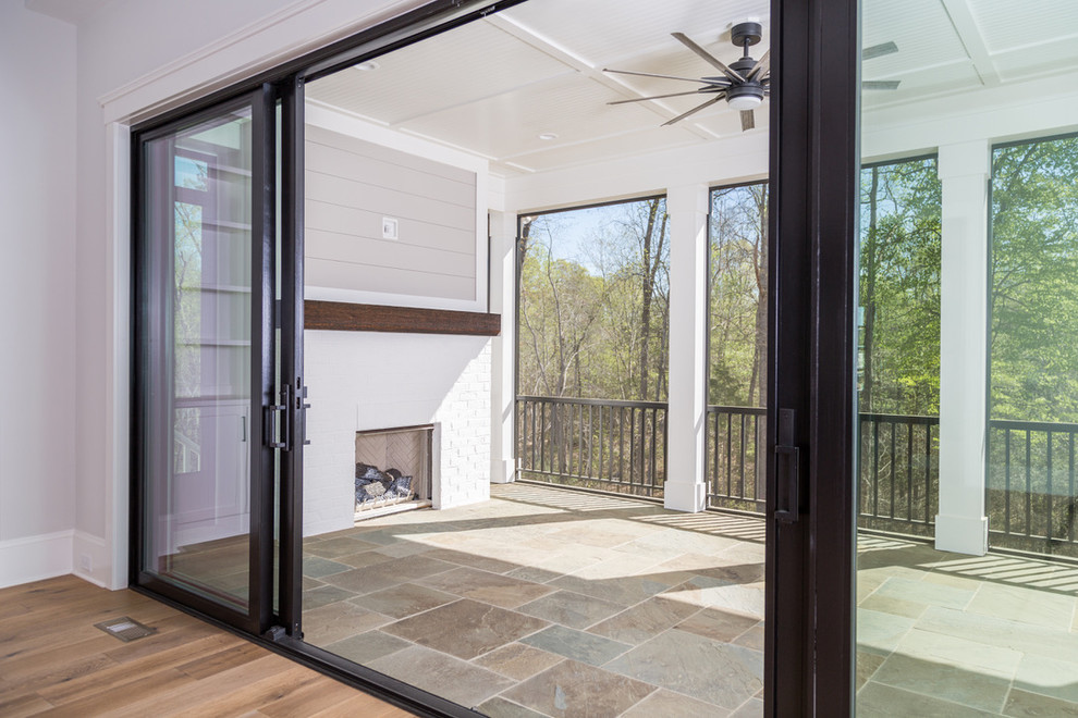 Mid-sized modern backyard verandah in Charlotte with with fireplace and natural stone pavers.