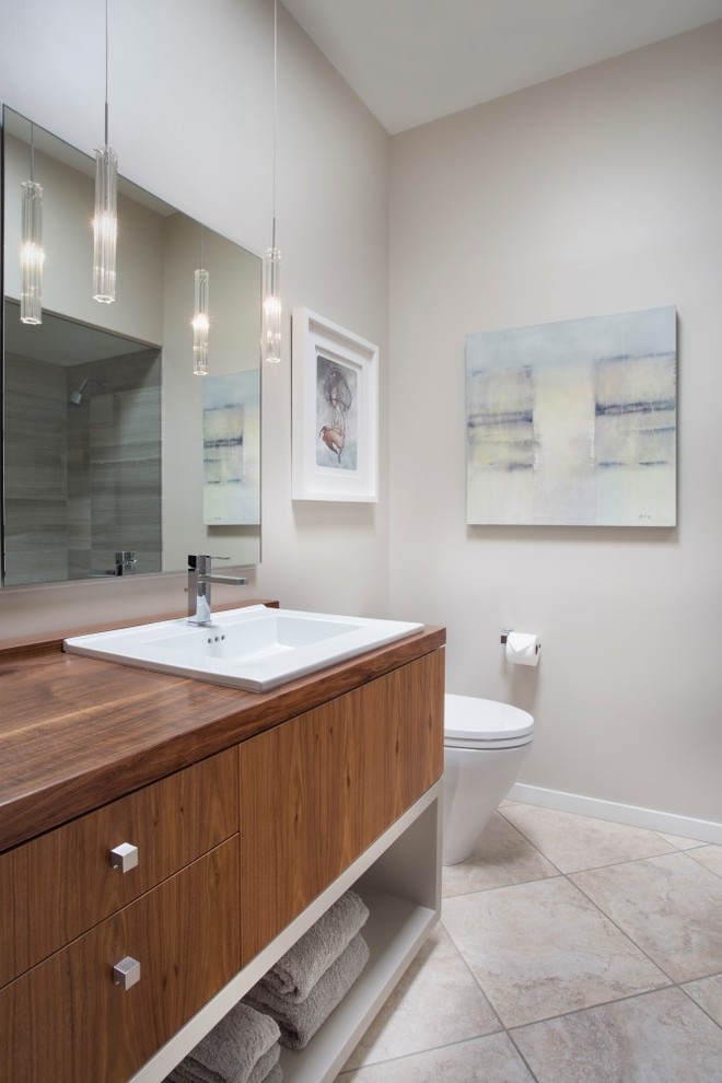 Inspiration for a mid-sized contemporary 3/4 bathroom in Phoenix with flat-panel cabinets, medium wood cabinets, an alcove shower, a one-piece toilet, grey walls, ceramic floors, a drop-in sink, wood benchtops and beige floor.