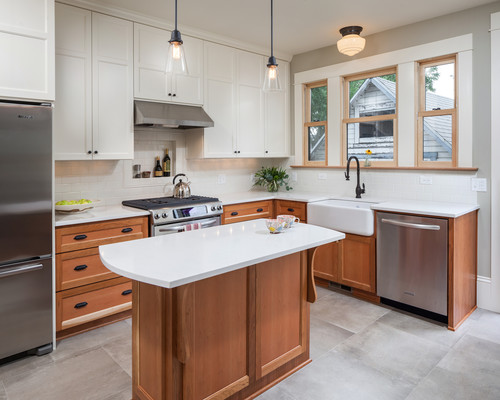 Transitional kitchen with white upper cabinets, wood base cabinets, small island, and farmhouse sink