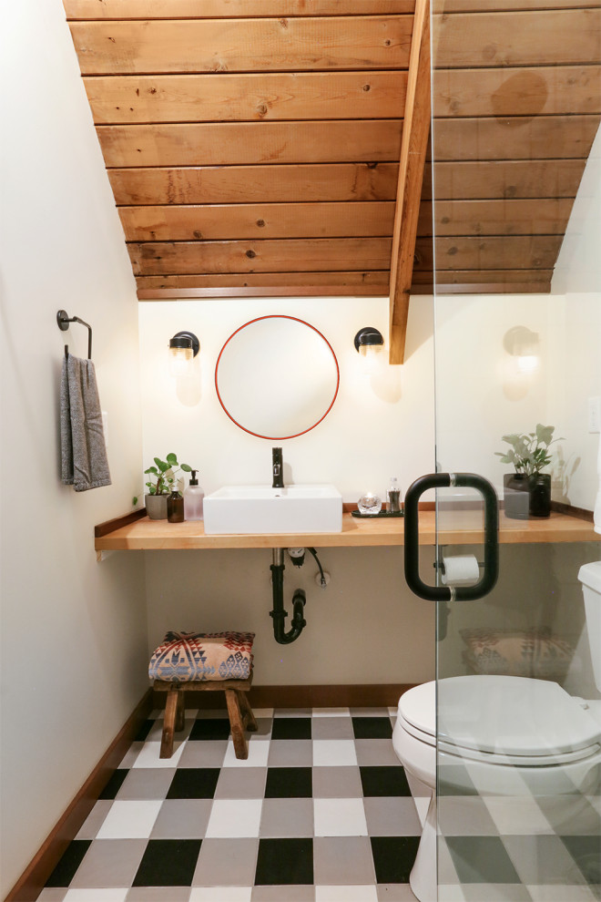 Small country bathroom in Portland with medium wood cabinets, a corner shower, a one-piece toilet, white tile, ceramic tile, white walls, ceramic floors, a pedestal sink, wood benchtops, multi-coloured floor, a hinged shower door, a single vanity and a floating vanity.