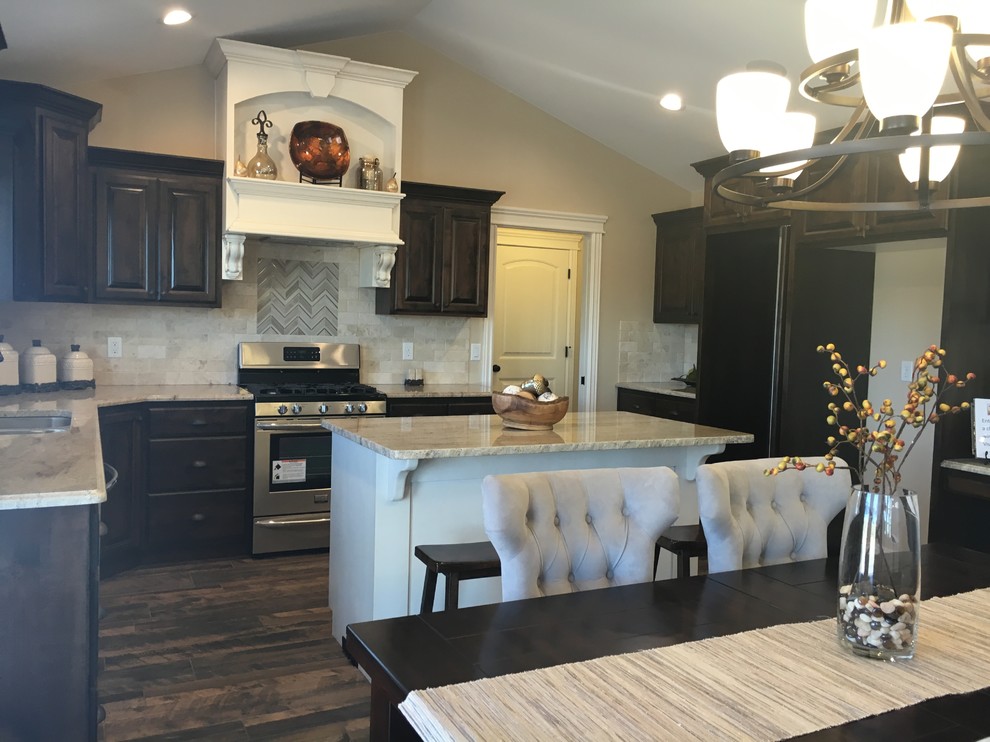 Inspiration for a large transitional u-shaped porcelain tile open concept kitchen remodel with an undermount sink, raised-panel cabinets, dark wood cabinets, granite countertops, beige backsplash, stone tile backsplash, stainless steel appliances and an island