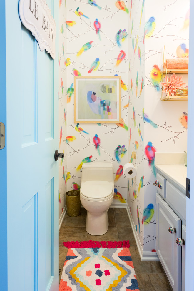 Photo of a small eclectic powder room in Kansas City with raised-panel cabinets, white cabinets, a one-piece toilet and multi-coloured walls.