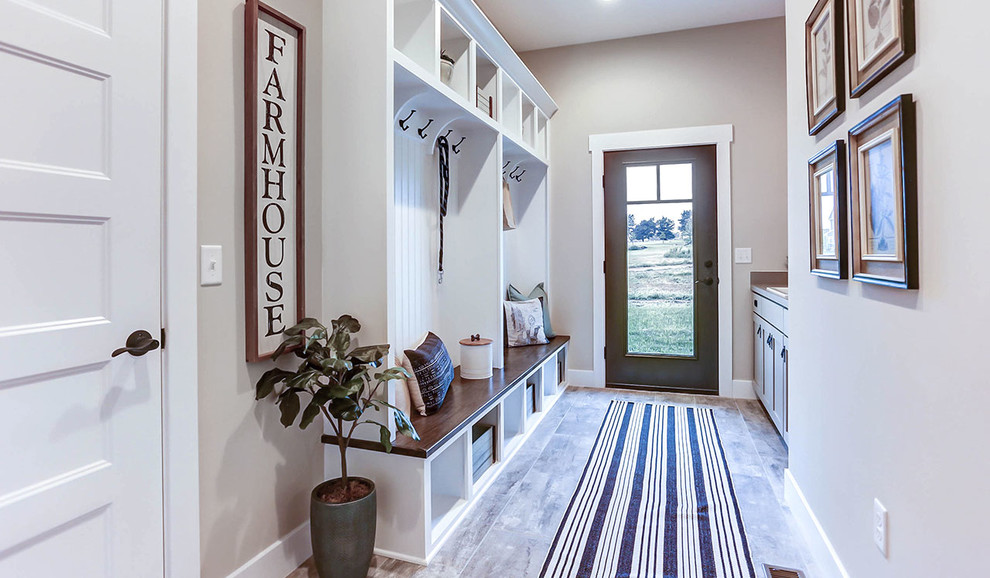 Expansive country mudroom in Other with grey walls, ceramic floors, a single front door and a dark wood front door.