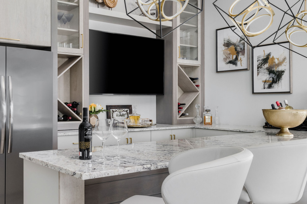 This is an example of a large transitional seated home bar in Jacksonville with an undermount sink, flat-panel cabinets, grey cabinets, granite benchtops, white splashback and white benchtop.