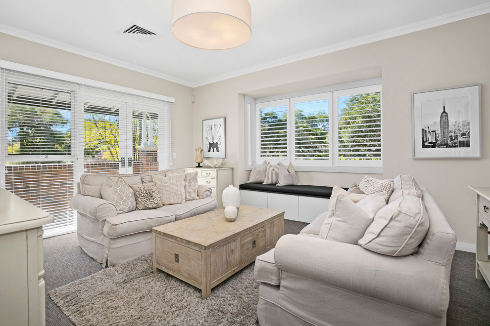 Design ideas for a mid-sized contemporary enclosed living room in Sydney with beige walls, carpet and a freestanding tv.