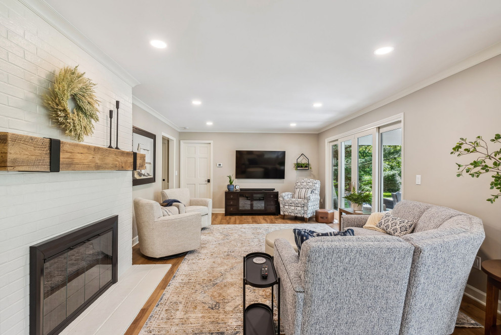 Medium sized classic open plan living room in Columbus with beige walls, vinyl flooring, a standard fireplace, a brick fireplace surround and brown floors.