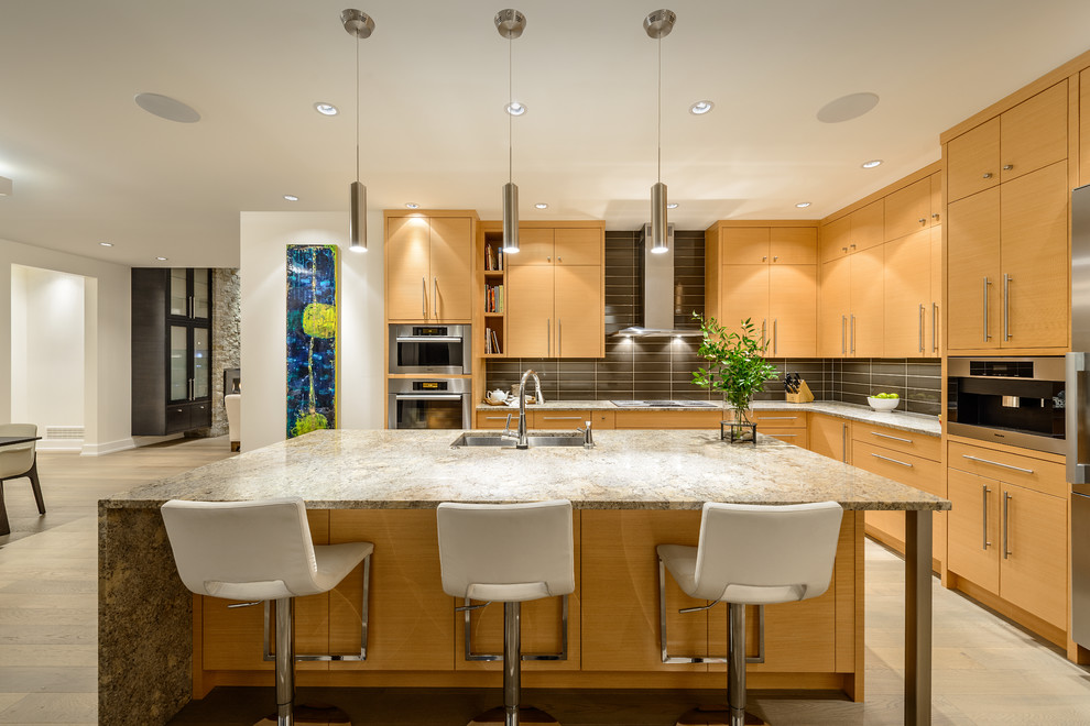 Photo of a mid-sized contemporary l-shaped eat-in kitchen in Vancouver with an undermount sink, light wood cabinets, granite benchtops, grey splashback, stainless steel appliances, medium hardwood floors and with island.