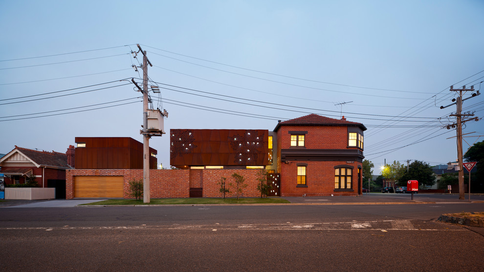 Large traditional two-storey brown exterior in Melbourne with metal siding and a flat roof.