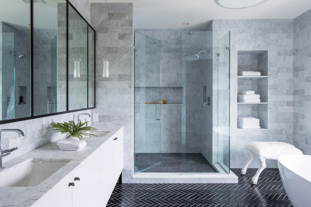 Example of a large trendy master gray tile and stone tile mosaic tile floor, black floor and double-sink bathroom design in Minneapolis with flat-panel cabinets, white cabinets, gray walls, an undermount sink, marble countertops, a hinged shower door, white countertops and a freestanding vanity
