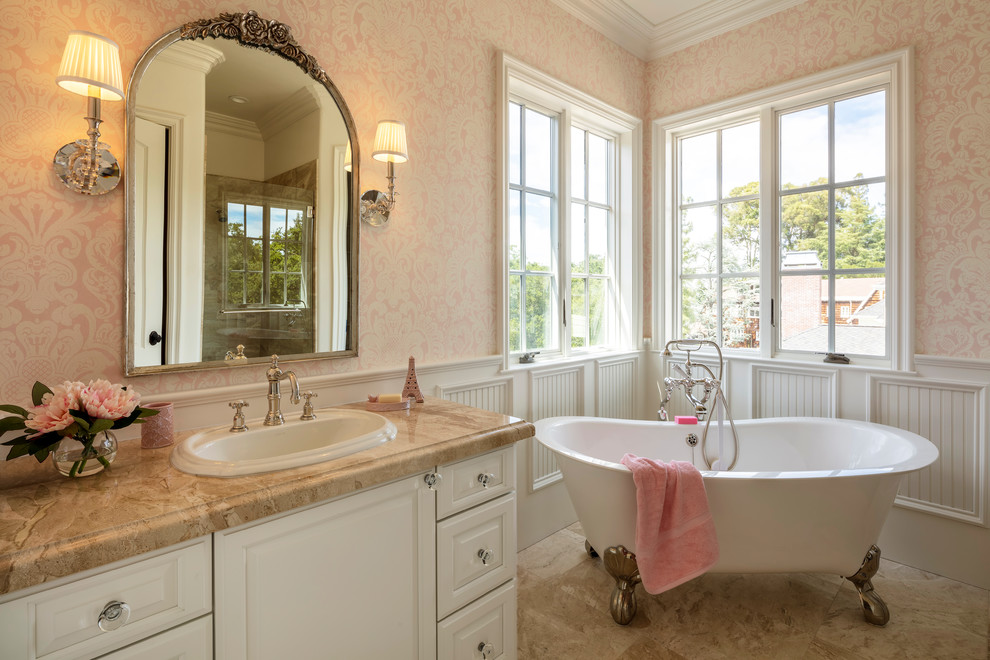 This is an example of a mid-sized traditional 3/4 bathroom in San Francisco with shaker cabinets, white cabinets, a freestanding tub, an alcove shower, pink walls, marble floors, a drop-in sink, granite benchtops, beige floor, a hinged shower door and beige benchtops.