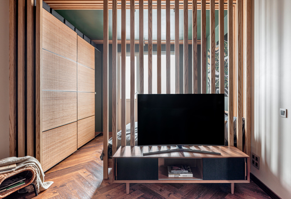 Exempel på ett litet modernt vardagsrum, med gröna väggar, laminatgolv, en fristående TV och brunt golv