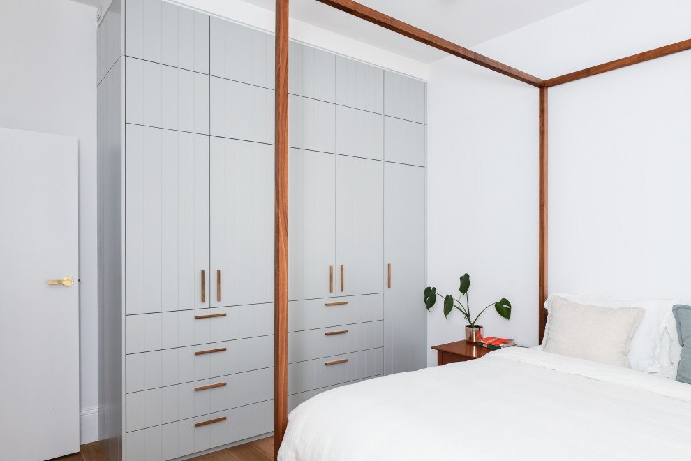 Стильный дизайн: встроенный шкаф среднего размера, унисекс в морском стиле с серыми фасадами и коричневым полом - последний тренд
