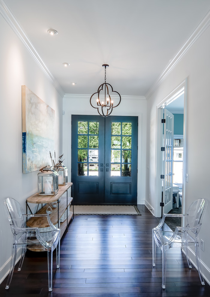 Inspiration for a mid-sized eclectic foyer in Cleveland with white walls, dark hardwood floors, a double front door and brown floor.
