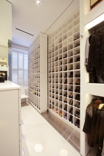 Photo of a large contemporary women's walk-in wardrobe in DC Metro with white cabinets, carpet and open cabinets.