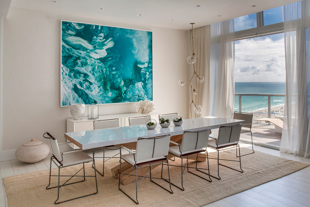 Design ideas for a beach style dining room in Miami with beige walls and light hardwood floors.
