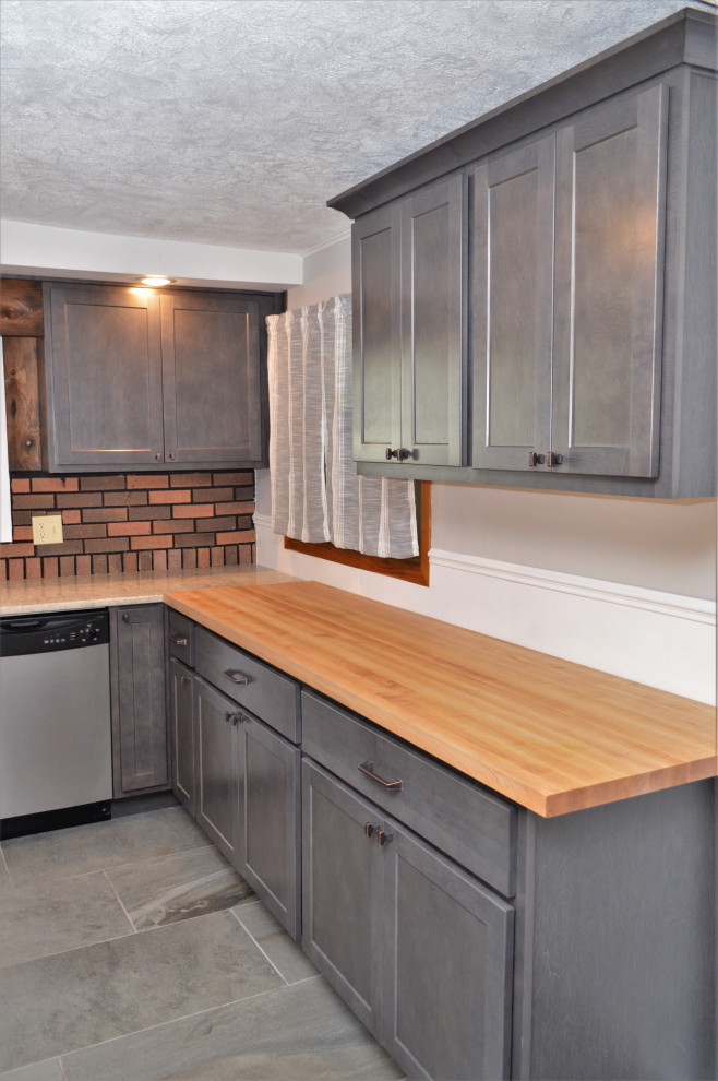 Photo of a mid-sized country u-shaped eat-in kitchen in Other with an undermount sink, shaker cabinets, grey cabinets, wood benchtops, red splashback, brick splashback, stainless steel appliances, slate floors, no island, grey floor and brown benchtop.