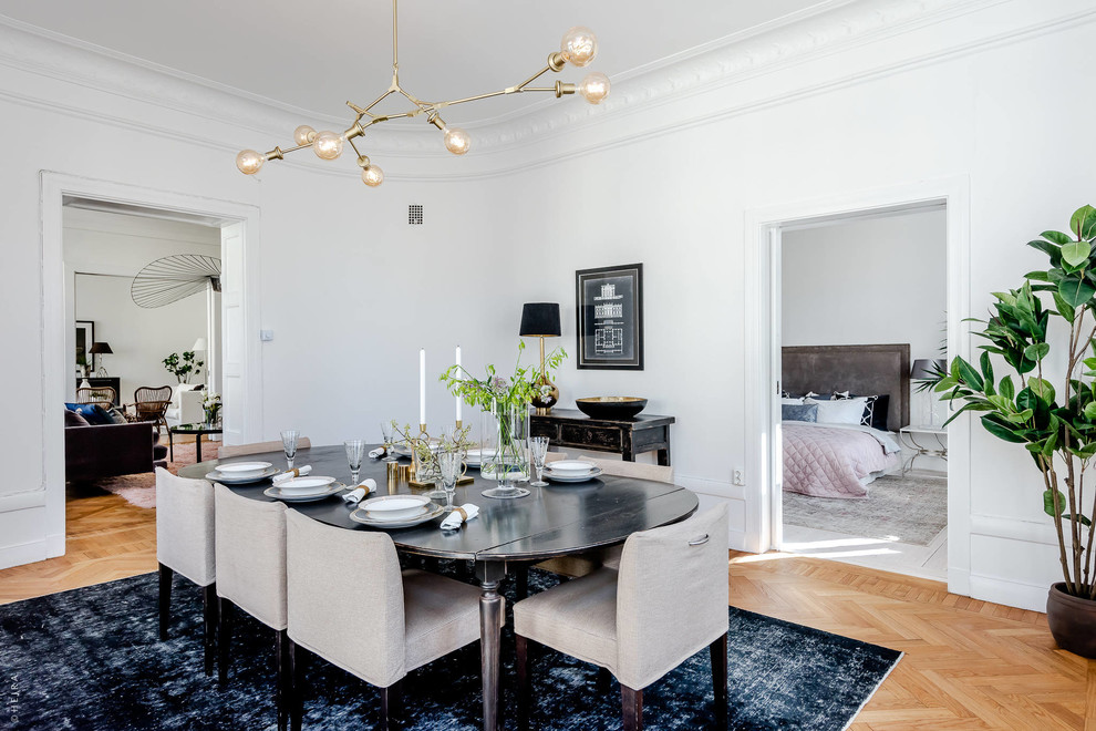 Inspiration for a scandinavian separate dining room in Stockholm with white walls, light hardwood floors and beige floor.
