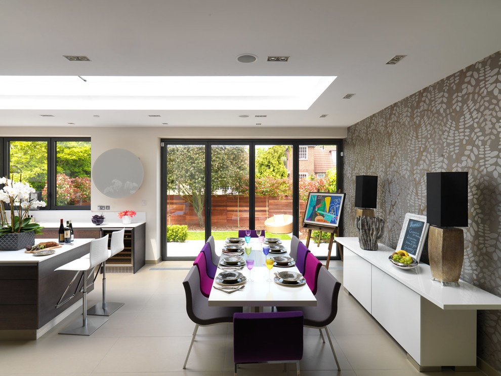 Large contemporary kitchen/dining combo in London with multi-coloured walls and ceramic floors.
