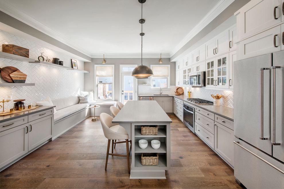 Photo of a transitional u-shaped eat-in kitchen in Atlanta with an undermount sink, shaker cabinets, grey cabinets, white splashback, subway tile splashback, stainless steel appliances, dark hardwood floors and with island.