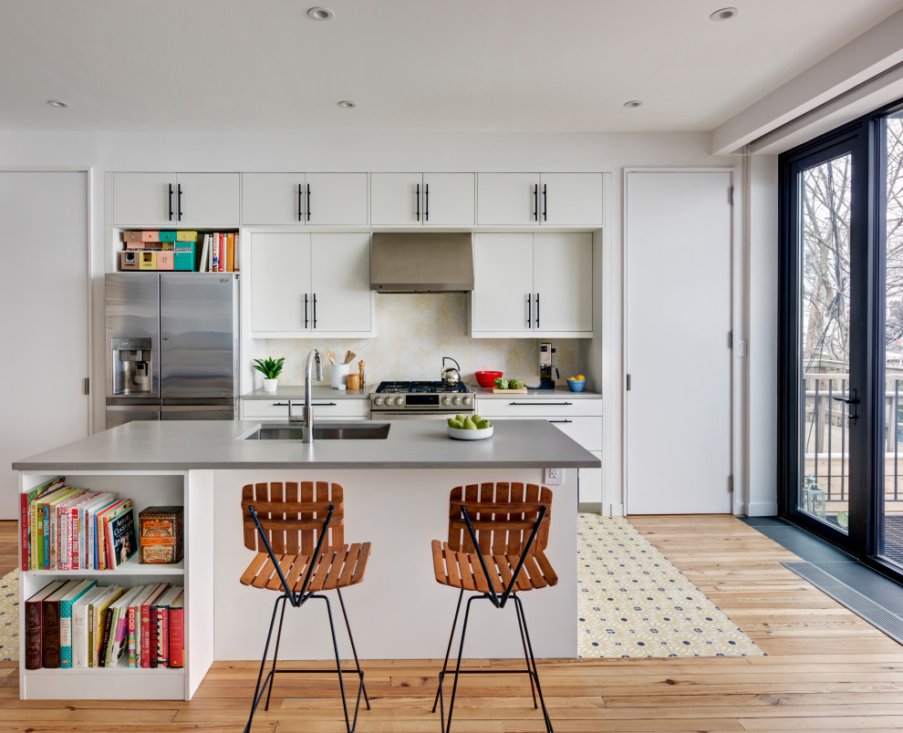 Design ideas for an eclectic galley kitchen in New York with an undermount sink, flat-panel cabinets, white cabinets, quartz benchtops, yellow splashback, cement tile splashback, stainless steel appliances, cement tiles, with island, yellow floor and grey benchtop.