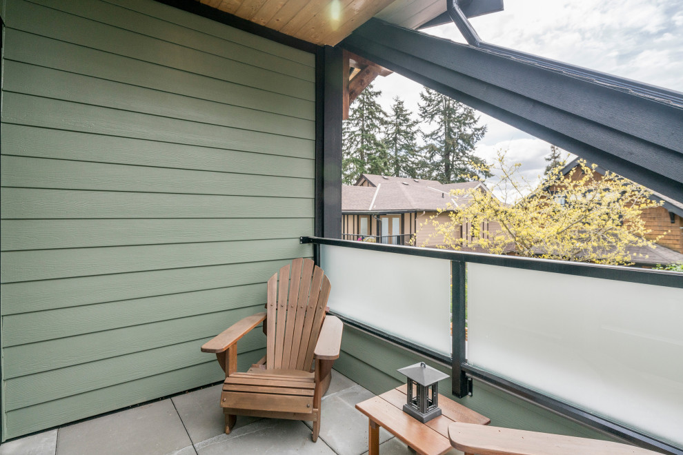 Small arts and crafts balcony in Vancouver with a roof extension and metal railing.