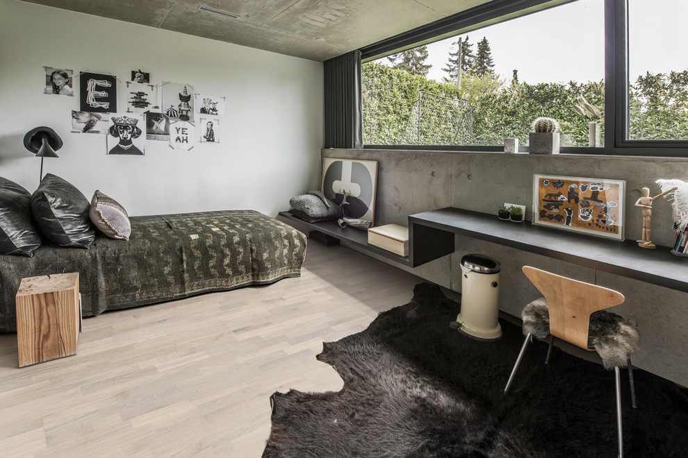 Mid-sized industrial guest bedroom with beige walls, light hardwood floors, no fireplace and beige floor.