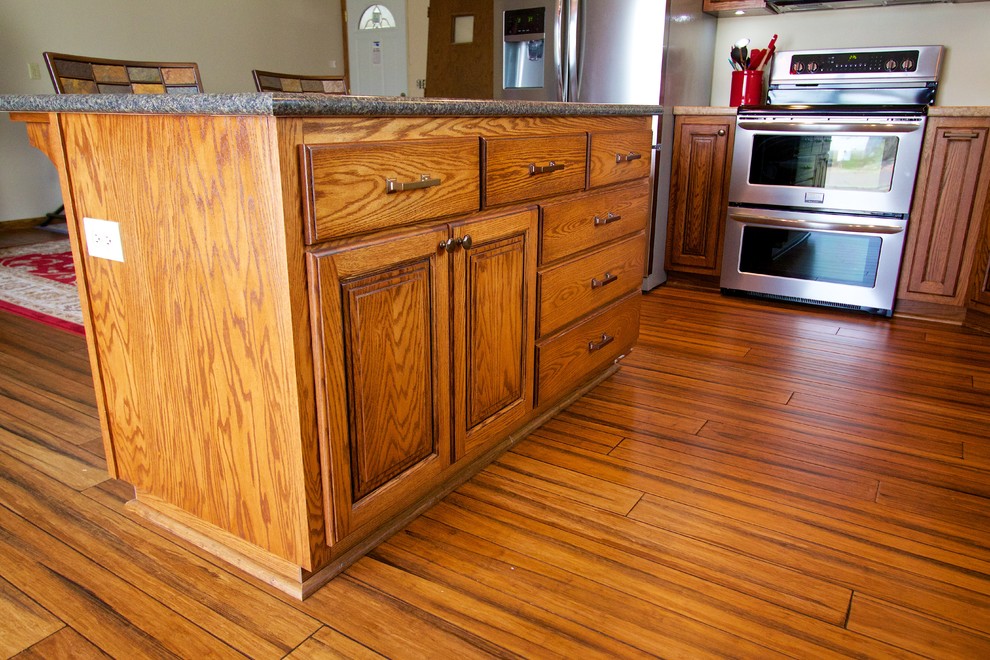 Inspiration for a mid-sized kitchen remodel with raised-panel cabinets, medium tone wood cabinets, laminate countertops and an island