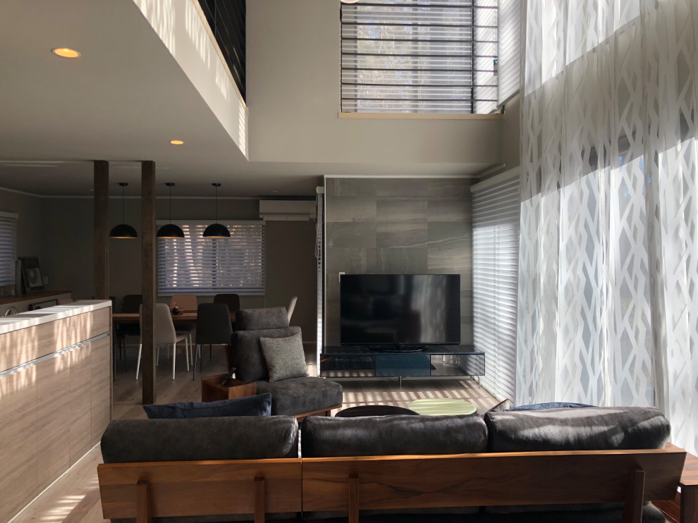 Стильный дизайн: большая парадная гостиная комната в стиле модернизм с серыми стенами, полом из фанеры, отдельно стоящим телевизором и серым полом - последний тренд