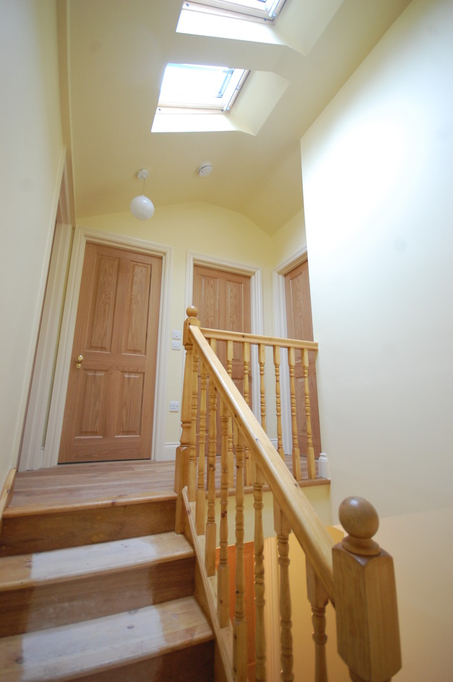 This is an example of a mid-sized traditional hallway in London with yellow walls and light hardwood floors.