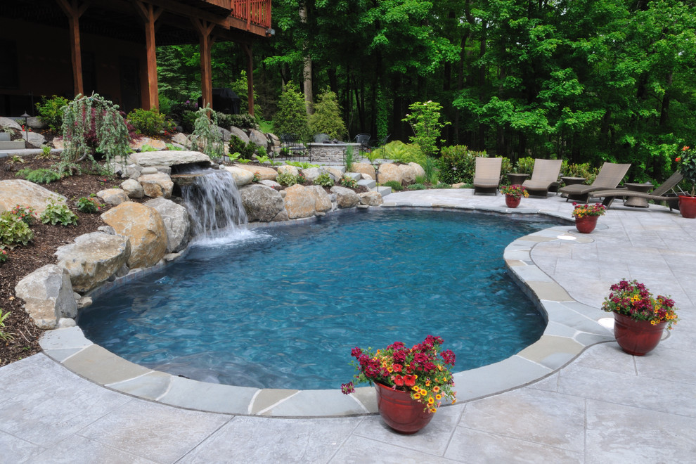 Design ideas for a large country backyard custom-shaped natural pool in Philadelphia with a hot tub and natural stone pavers.