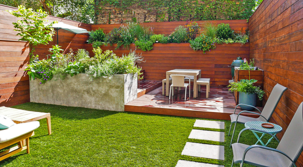 Design ideas for a small contemporary backyard full sun garden in New York with with privacy feature and decking.