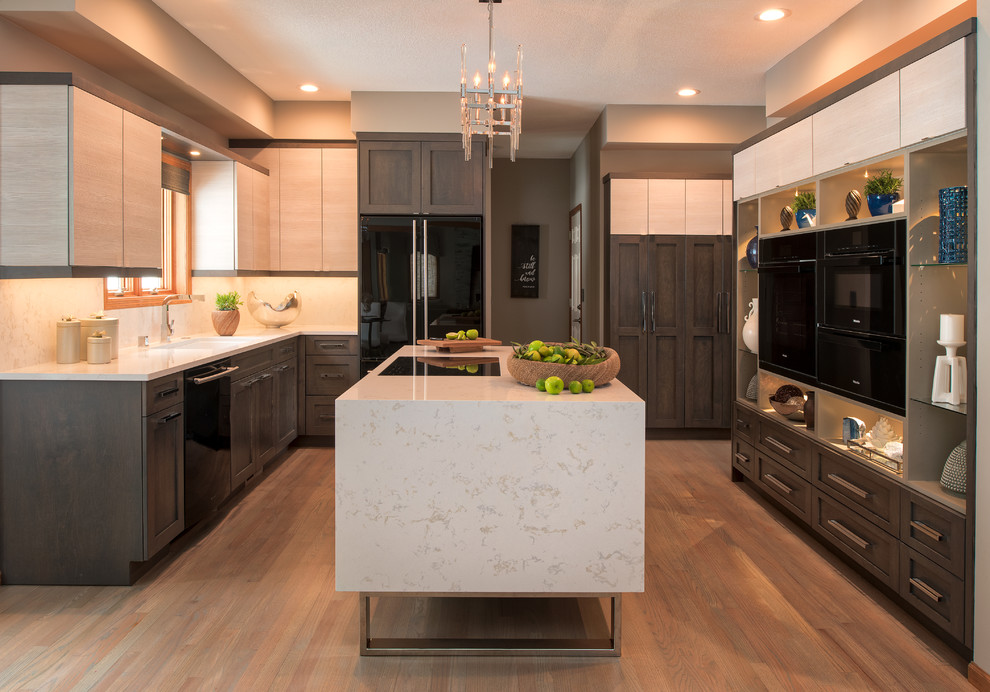 Mid-sized transitional u-shaped separate kitchen in Minneapolis with an undermount sink, recessed-panel cabinets, quartz benchtops, white splashback, marble splashback, black appliances, with island, white benchtop, dark wood cabinets, medium hardwood floors and brown floor.