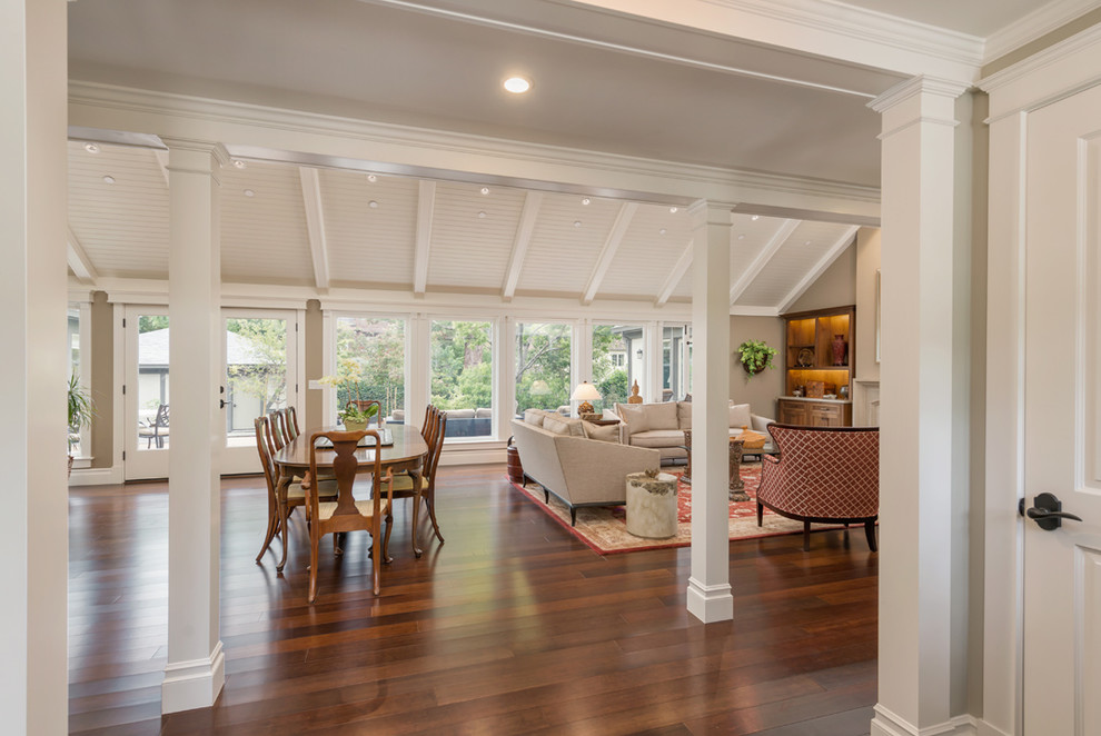 This is an example of a traditional open plan dining in San Francisco with beige walls and bamboo floors.
