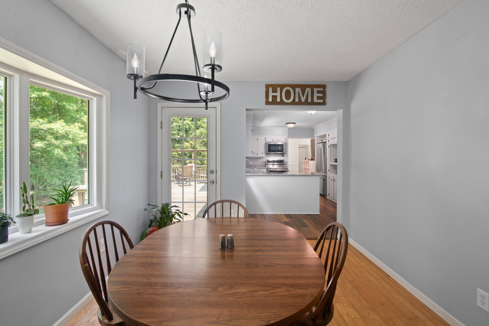 Mid-sized transitional medium tone wood floor and brown floor kitchen/dining room combo photo with white walls