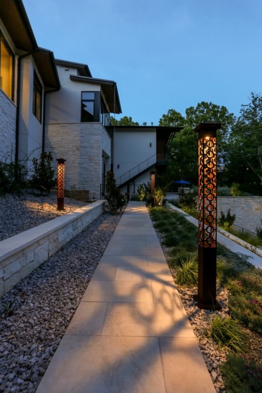 Large modern sloped garden in Austin with a retaining wall.