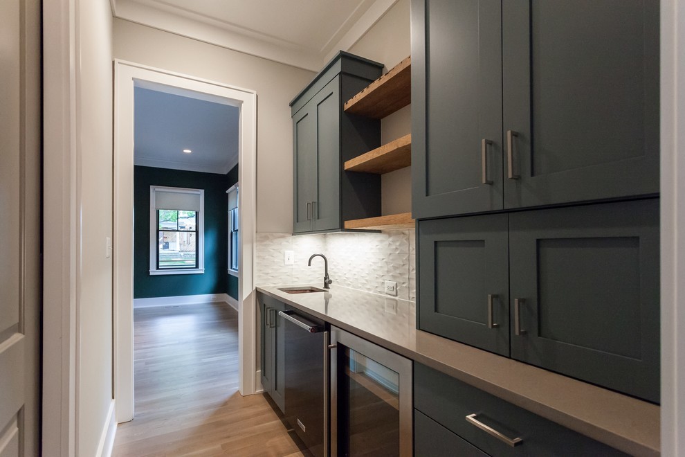Photo of a contemporary single-wall kitchen pantry in DC Metro with an undermount sink, shaker cabinets, blue cabinets, grey splashback, stainless steel appliances, light hardwood floors, beige floor and grey benchtop.