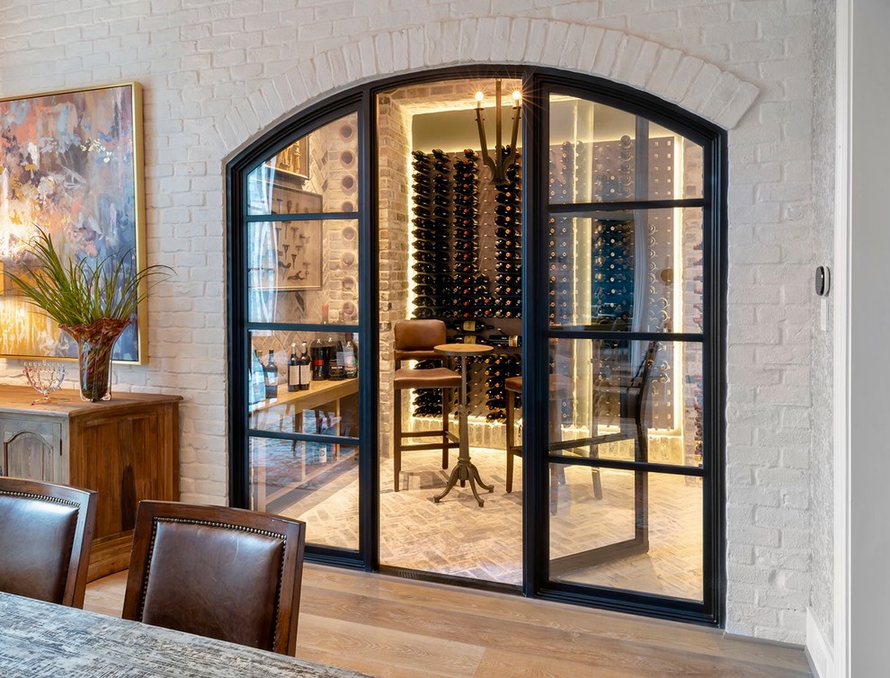 Inspiration for a mid-sized transitional wine cellar in Houston with brick floors, display racks and grey floor.