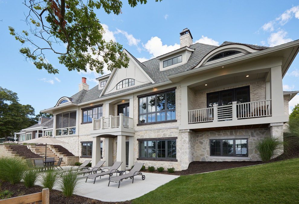 Großes, Einstöckiges Einfamilienhaus mit Mix-Fassade, beiger Fassadenfarbe, Mansardendach, Schindeldach und grauem Dach in Grand Rapids