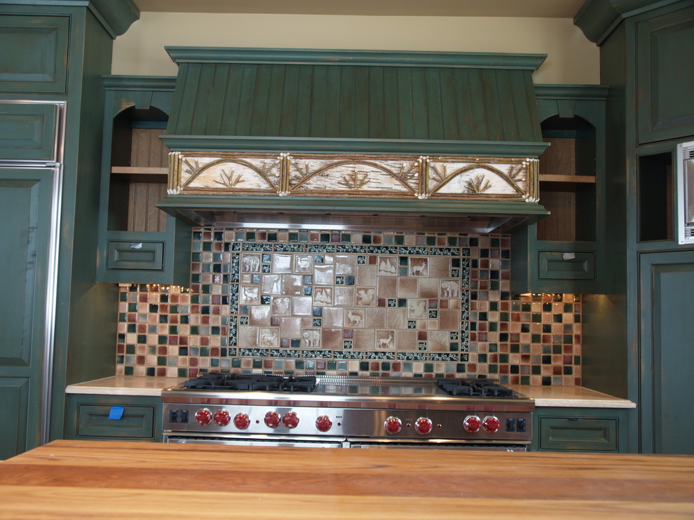 Example of a mid-sized mountain style l-shaped enclosed kitchen design in Burlington with an island, an undermount sink, raised-panel cabinets, blue cabinets, limestone countertops, multicolored backsplash, cement tile backsplash and stainless steel appliances