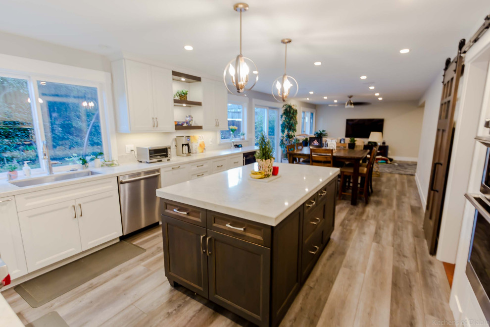 Example of a large transitional u-shaped medium tone wood floor and gray floor open concept kitchen design in San Francisco with an undermount sink, recessed-panel cabinets, white cabinets, quartz countertops, white backsplash, marble backsplash, stainless steel appliances, an island and white countertops