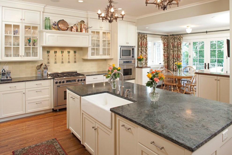 Design ideas for a large traditional eat-in kitchen in Minneapolis with a farmhouse sink, recessed-panel cabinets, white cabinets, marble benchtops, beige splashback, ceramic splashback, stainless steel appliances, medium hardwood floors and with island.