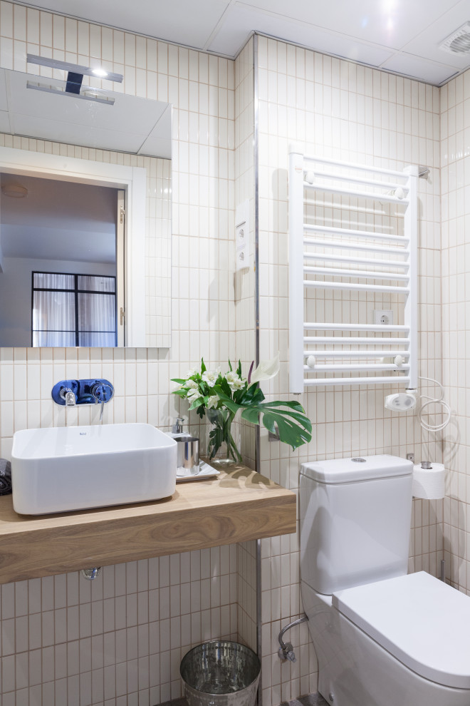 Inspiration for a small contemporary 3/4 bathroom in Madrid with medium wood cabinets, a one-piece toilet, white tile, beige tile, ceramic tile, a vessel sink, wood benchtops, multi-coloured walls and beige benchtops.