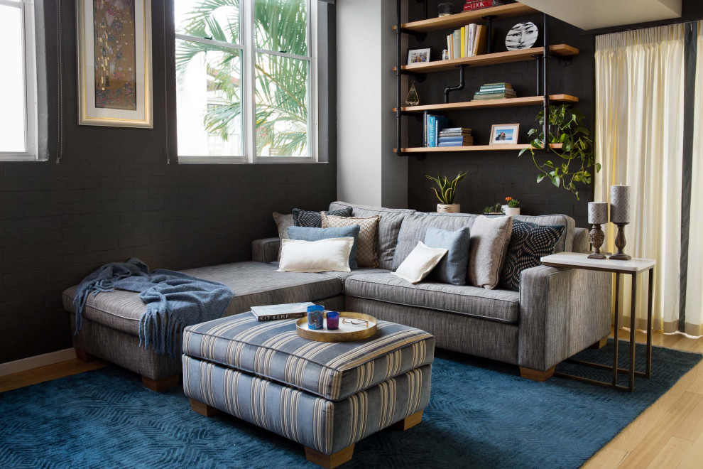 Mittelgroßes, Offenes Industrial Wohnzimmer ohne Kamin mit grauer Wandfarbe, hellem Holzboden, freistehendem TV, braunem Boden, freigelegten Dachbalken und Ziegelwänden in Brisbane