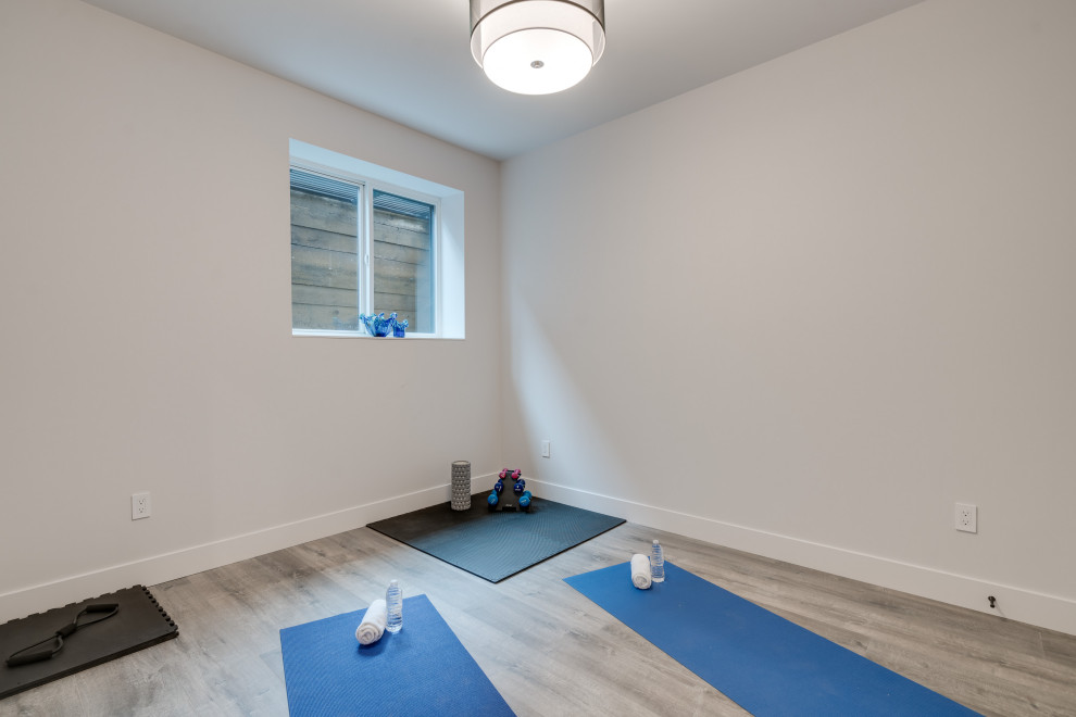 Small contemporary home yoga studio in Vancouver with light hardwood floors and grey floor.