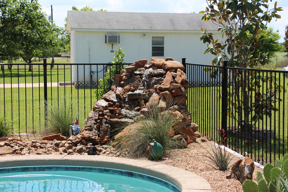 Example of a mid-sized transitional backyard gravel and custom-shaped lap pool fountain design in Austin