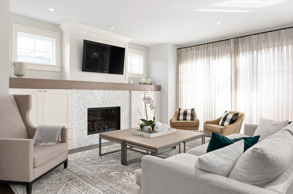 Photo of a mid-sized transitional open concept family room in Calgary with a library, white walls, medium hardwood floors, a standard fireplace, a tile fireplace surround, a wall-mounted tv and brown floor.