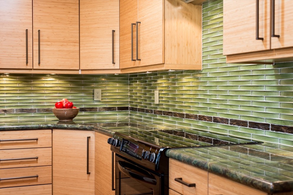 This is an example of a modern kitchen in San Diego with a farmhouse sink, shaker cabinets, light wood cabinets, granite benchtops, green splashback, glass tile splashback, medium hardwood floors and no island.