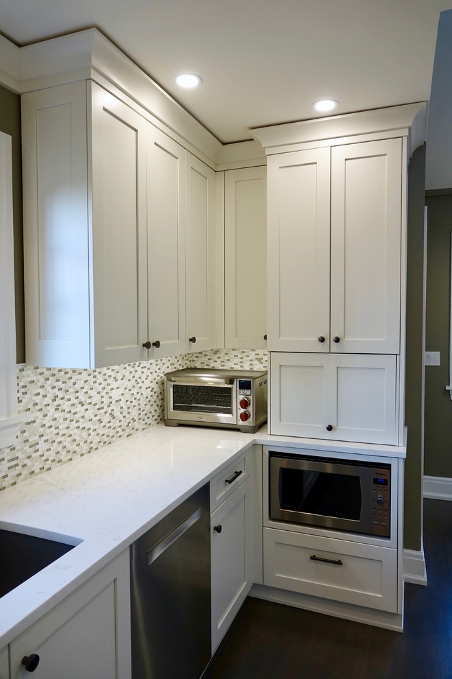 Mid-sized midcentury galley kitchen pantry in Seattle with an undermount sink, shaker cabinets, white cabinets, quartz benchtops, glass tile splashback, stainless steel appliances and white benchtop.