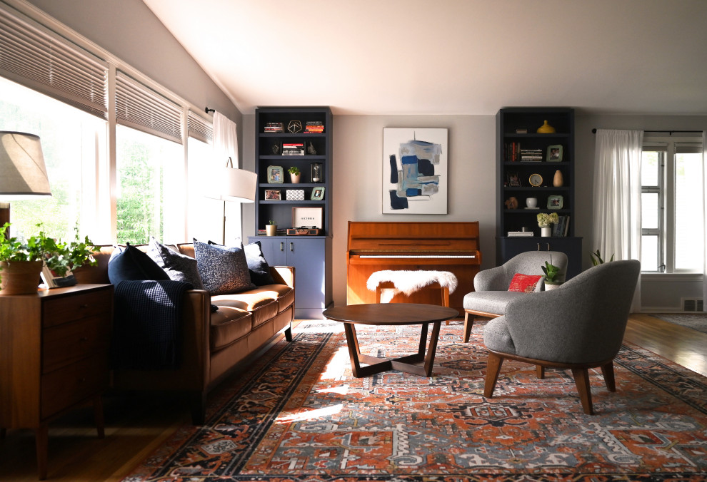 Diseño de salón abierto y abovedado vintage de tamaño medio con paredes grises y suelo de madera en tonos medios