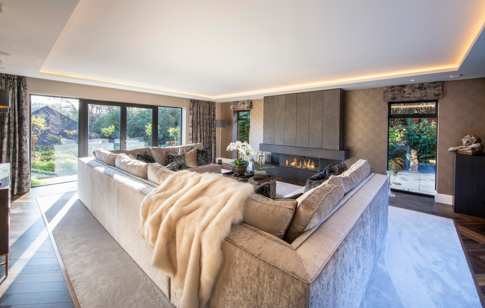Contemporary living room in Hampshire with brown walls, dark hardwood floors, a ribbon fireplace and brown floor.